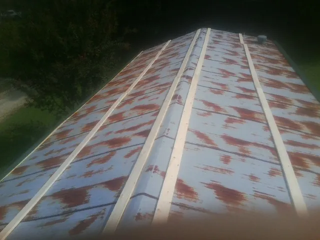 Rusted metal roof panels with new wood purlins before replacement — Storm Damage Roof Repair in Waubun by Roofing Brothers